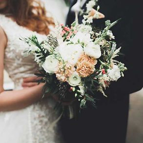 Schöner Hochzeitsstrauß mit verschiedenen Blumen in den Händen